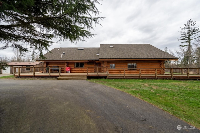 rear view of property with a lawn and a deck