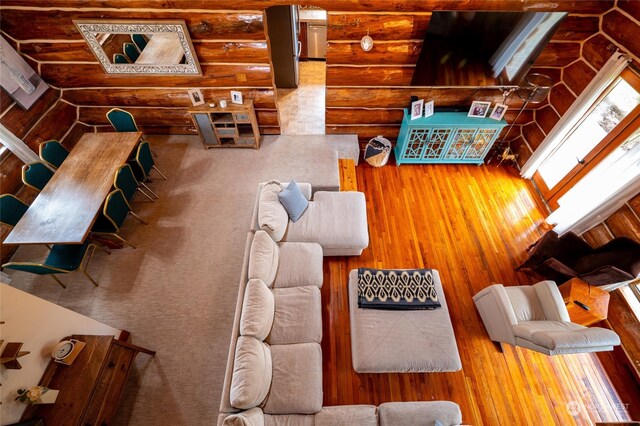 living room featuring wood-type flooring and rustic walls