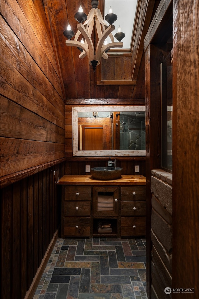 interior space featuring lofted ceiling, wood walls, and sink