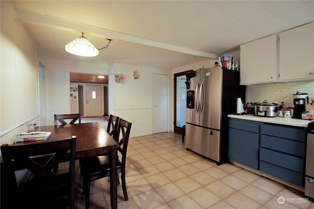 kitchen featuring white cabinets, appliances with stainless steel finishes, backsplash, and decorative light fixtures