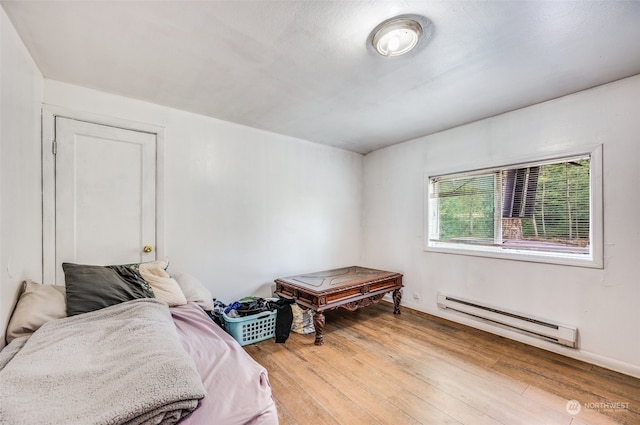 bedroom featuring a baseboard radiator and light wood-type flooring