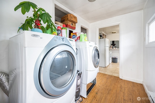 laundry room featuring hardwood / wood-style flooring and washer and dryer