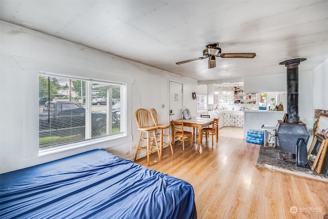 bedroom featuring light wood-type flooring and a wood stove