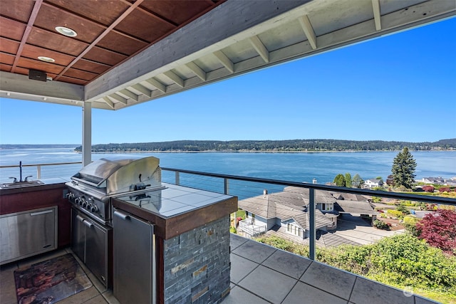 view of patio / terrace featuring sink, a water view, area for grilling, grilling area, and a balcony