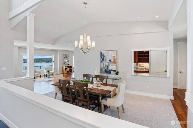 dining space featuring dark hardwood / wood-style flooring, vaulted ceiling, and a notable chandelier