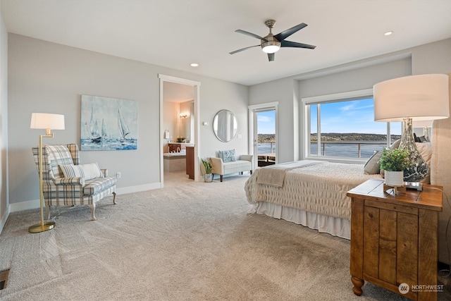 bedroom with a water view, ceiling fan, connected bathroom, and carpet