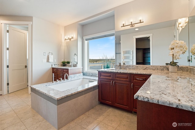 bathroom featuring vanity, tile patterned floors, and tiled bath