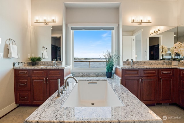 bathroom featuring vanity, tile patterned floors, and a water view