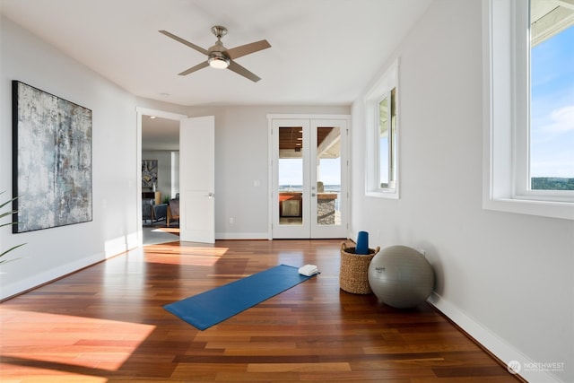 workout area featuring french doors, ceiling fan, and dark hardwood / wood-style floors