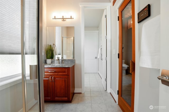 bathroom with vanity, tile patterned floors, toilet, and walk in shower