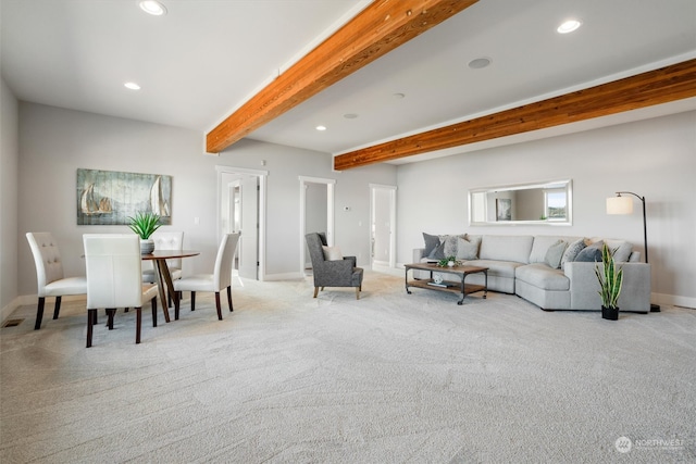 carpeted living room featuring beamed ceiling