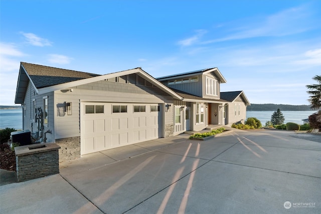 view of front of home with a garage and a water view