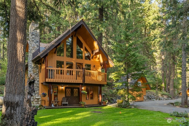 back of house featuring a wooden deck and a yard