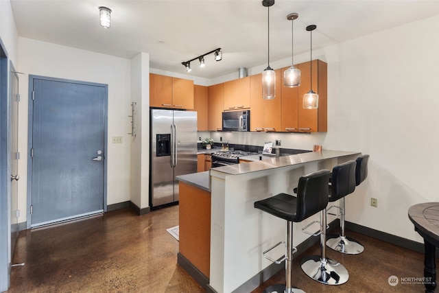 kitchen featuring decorative light fixtures, stainless steel appliances, kitchen peninsula, and a kitchen breakfast bar