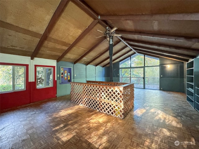 additional living space with ceiling fan, dark parquet floors, and vaulted ceiling with beams