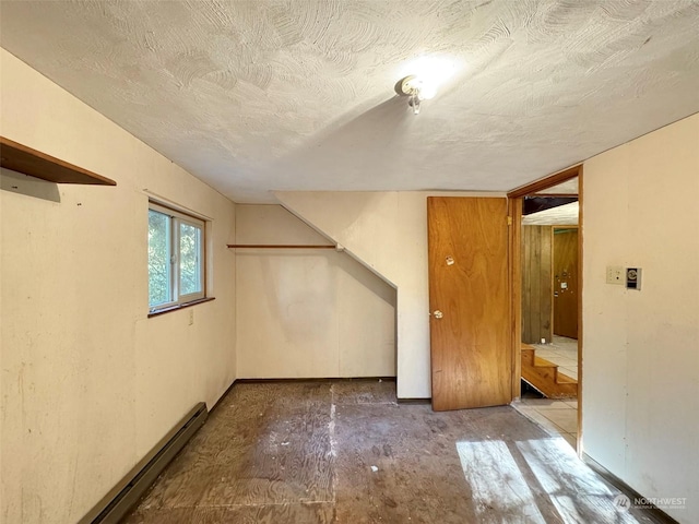 344 Dungeness Mdws, Sequim, WA 98382 - basement with a baseboard radiator, a textured ceiling, stairs, and baseboards