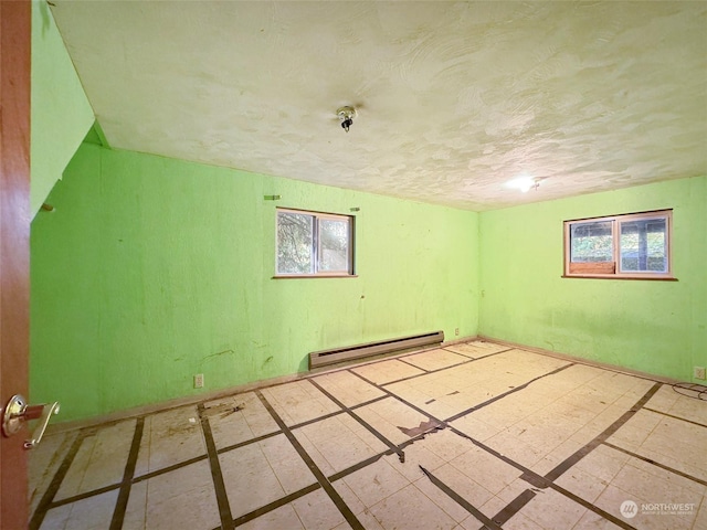 344 Dungeness Mdws, Sequim, WA 98382 - empty room featuring a baseboard radiator, healthy amount of natural light, a textured ceiling, and baseboards