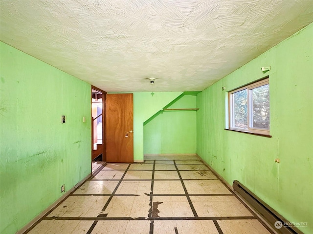 344 Dungeness Mdws, Sequim, WA 98382 - spare room featuring baseboard heating, baseboards, and a textured ceiling