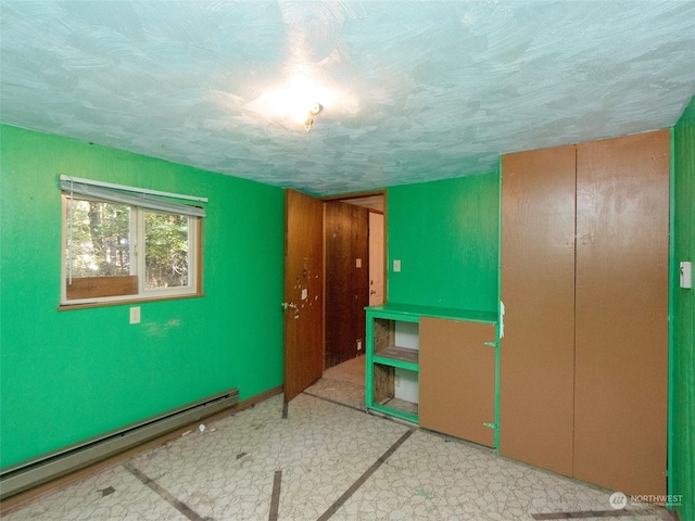 344 Dungeness Mdws, Sequim, WA 98382 - bedroom with a baseboard heating unit, tile patterned floors, a closet, and a textured ceiling
