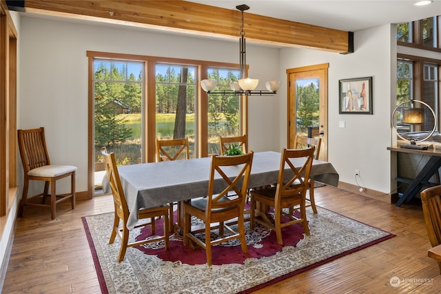 dining room featuring beamed ceiling, a chandelier, and hardwood / wood-style floors