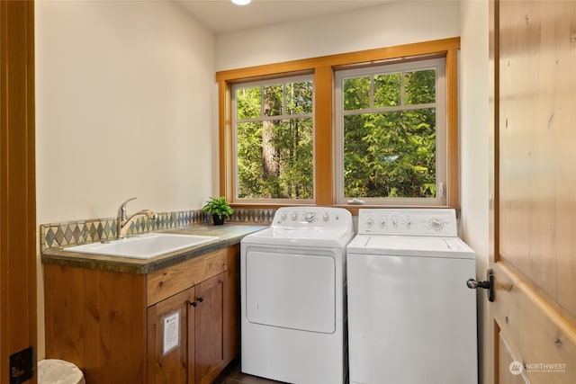 laundry room with washer and clothes dryer, sink, and cabinets