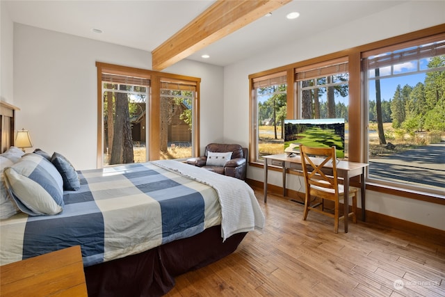 bedroom with beam ceiling and light hardwood / wood-style floors