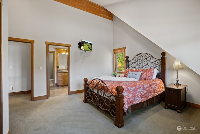 carpeted bedroom with high vaulted ceiling, connected bathroom, and beamed ceiling