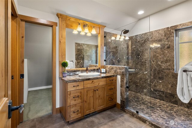 bathroom featuring tile patterned floors, vaulted ceiling, vanity, and tiled shower