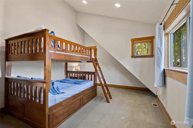 carpeted bedroom with lofted ceiling