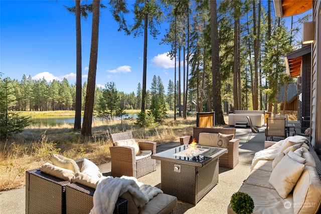 view of patio / terrace featuring a water view and an outdoor living space with a fire pit