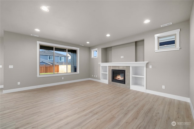 unfurnished living room with a fireplace and light hardwood / wood-style flooring