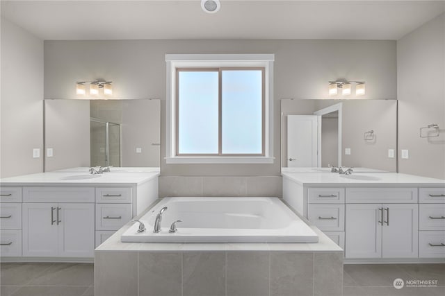 bathroom featuring shower with separate bathtub, vanity, and tile patterned floors