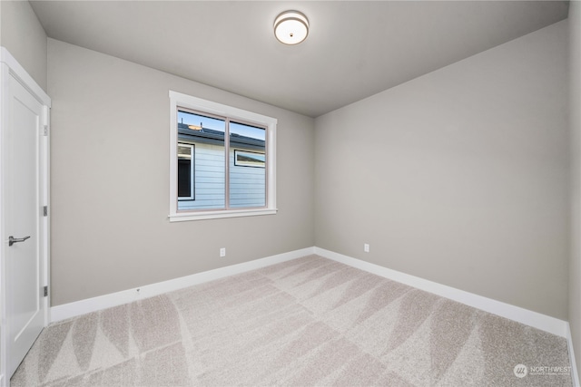 spare room featuring light colored carpet