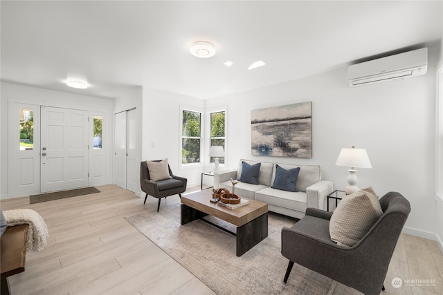 living room with light hardwood / wood-style flooring and a wall mounted air conditioner