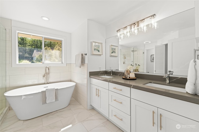 bathroom featuring tile walls, vanity, and separate shower and tub