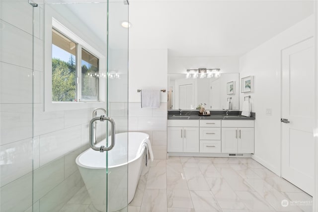 bathroom with tile walls, a bath, and vanity