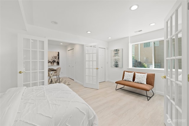 bedroom featuring french doors and light hardwood / wood-style flooring