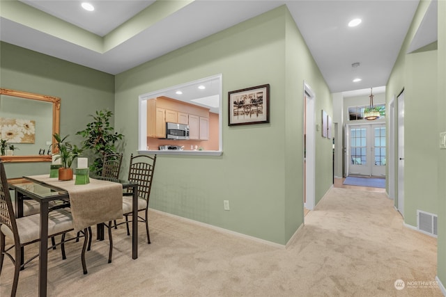 carpeted dining area with french doors