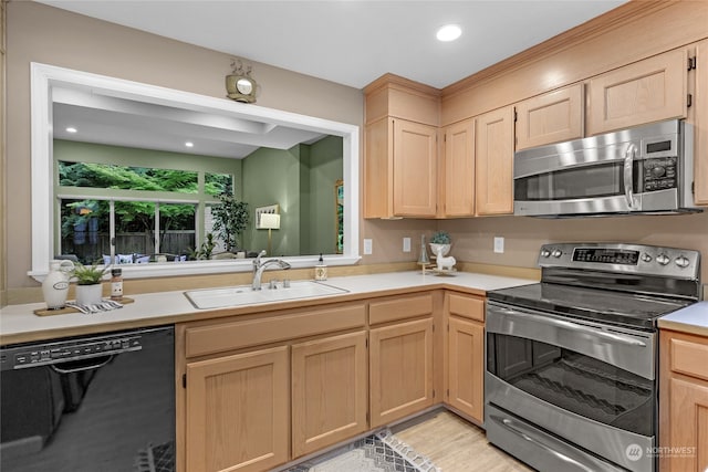 kitchen with stainless steel appliances, light brown cabinetry, and sink