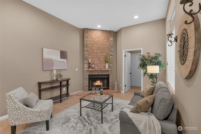 living room featuring light wood-type flooring and a fireplace