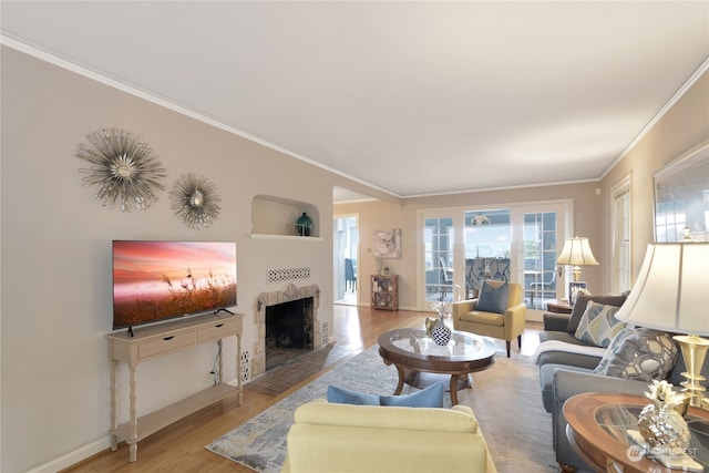 living room with light wood-type flooring, ornamental molding, and a tiled fireplace