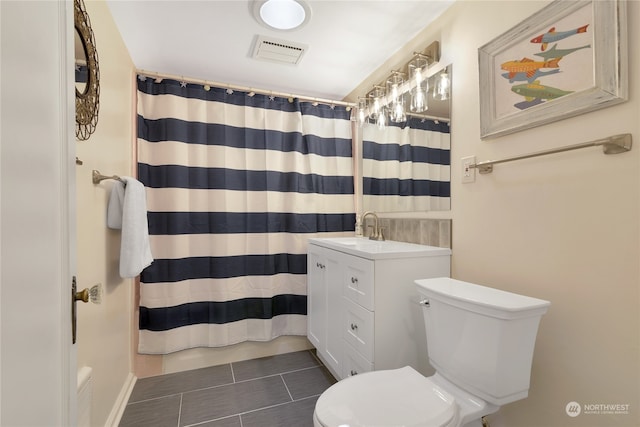 bathroom with tile patterned flooring, walk in shower, vanity, and toilet