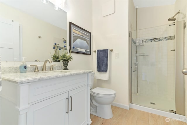 bathroom with a shower with shower door, vanity, toilet, and hardwood / wood-style flooring