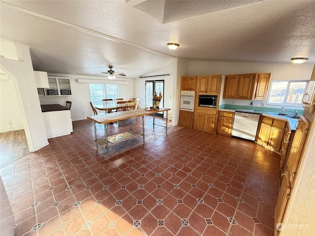 kitchen featuring lofted ceiling, a textured ceiling, appliances with stainless steel finishes, and ceiling fan