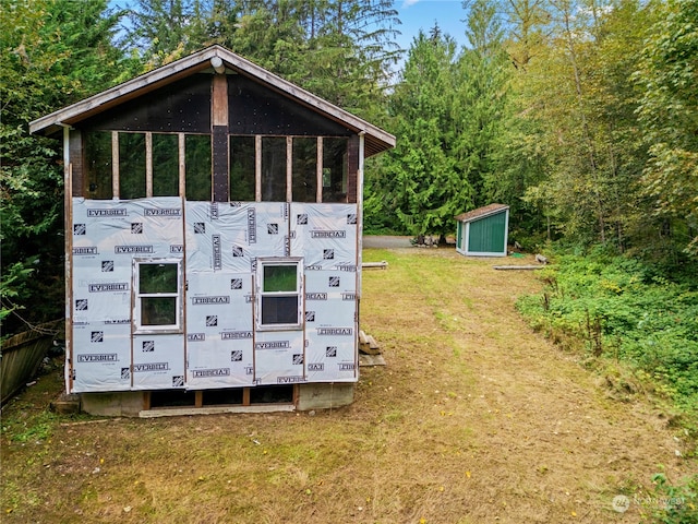 view of outdoor structure featuring a yard and a sunroom