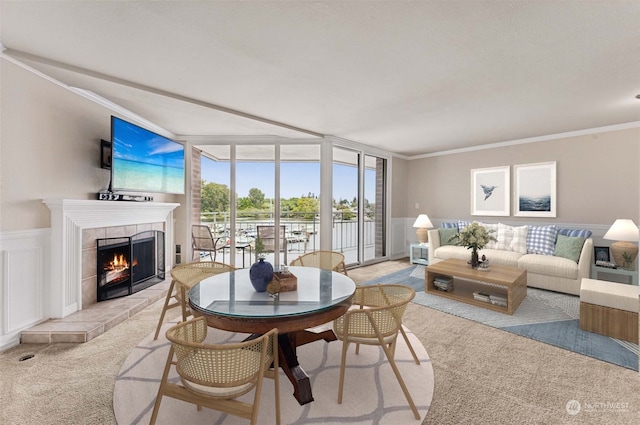 living room featuring light carpet, floor to ceiling windows, a tile fireplace, and crown molding