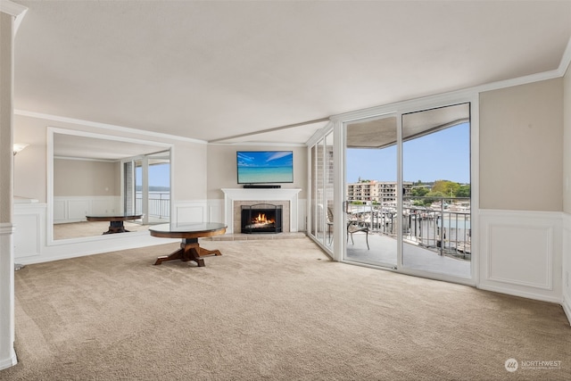 unfurnished living room featuring crown molding, a fireplace, and light carpet