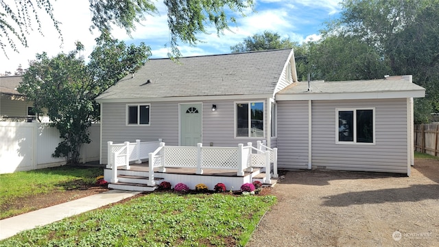 view of front of property featuring a front lawn and a deck