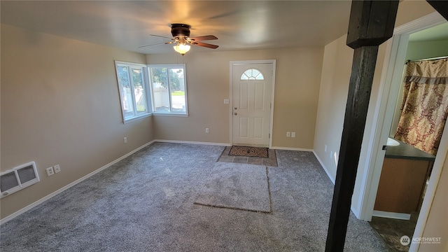 carpeted foyer entrance featuring ceiling fan