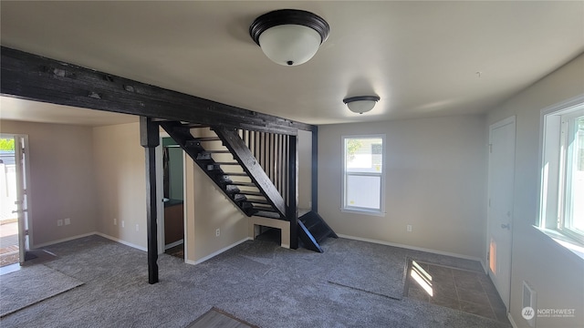 workout room featuring dark carpet and a healthy amount of sunlight